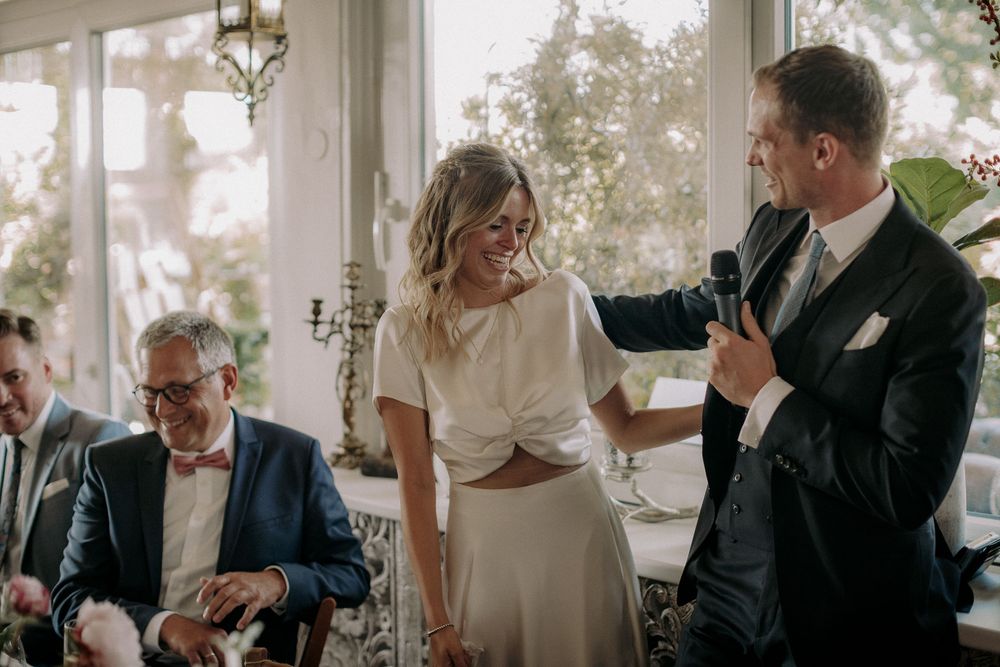 Emotional moment during speeches at an elegant indoor wedding reception.