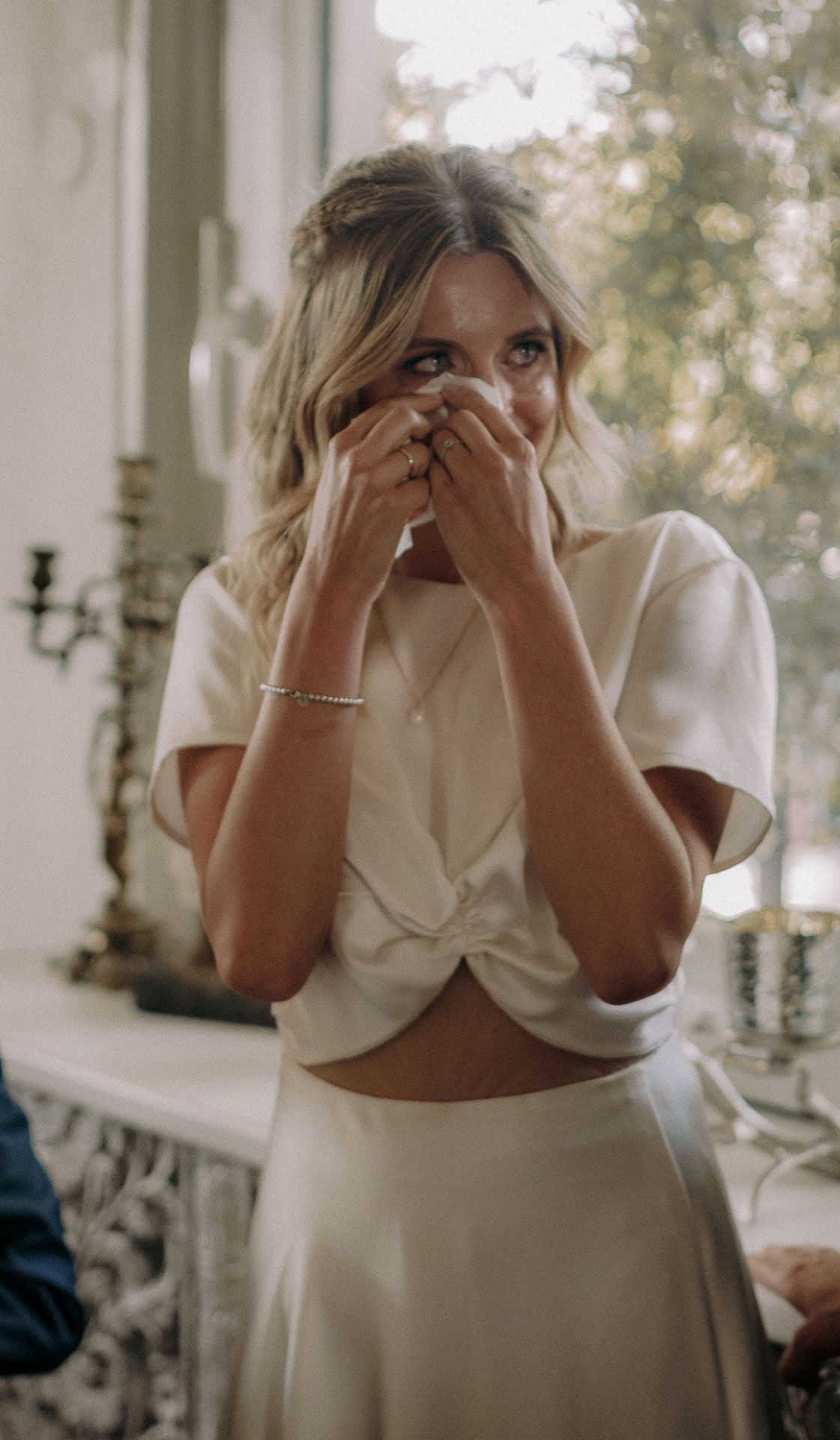 Emotional moment captured in white formal attire during celebration.