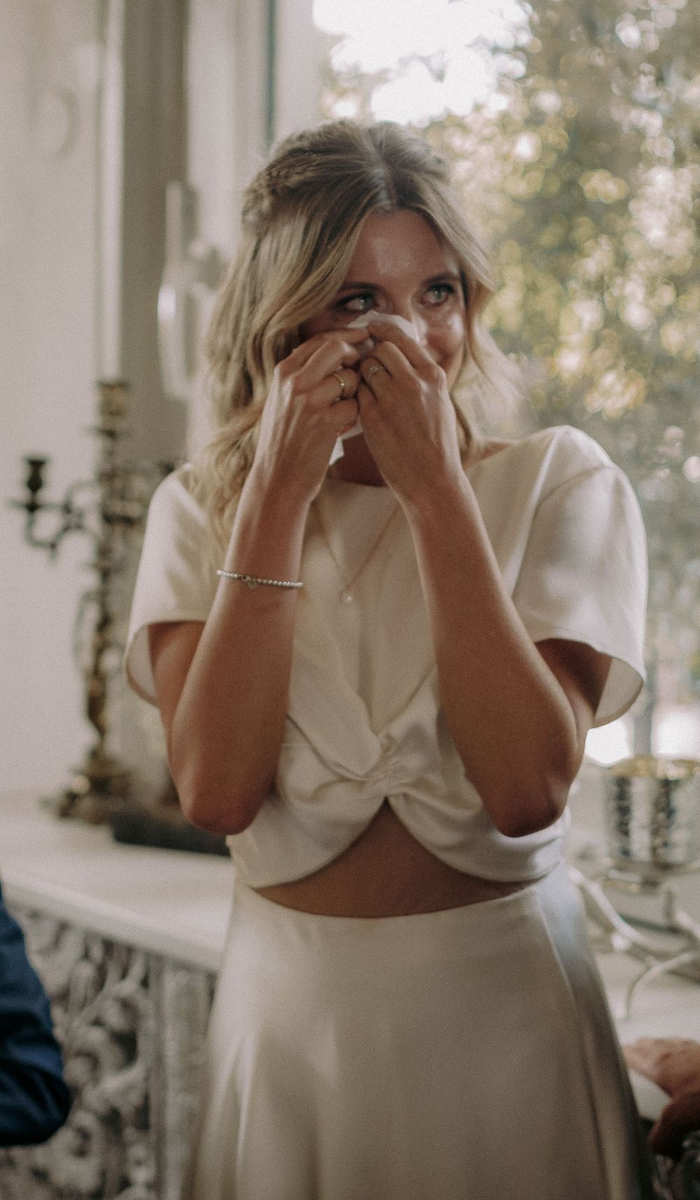 Emotional moment captured in white formal attire during celebration.