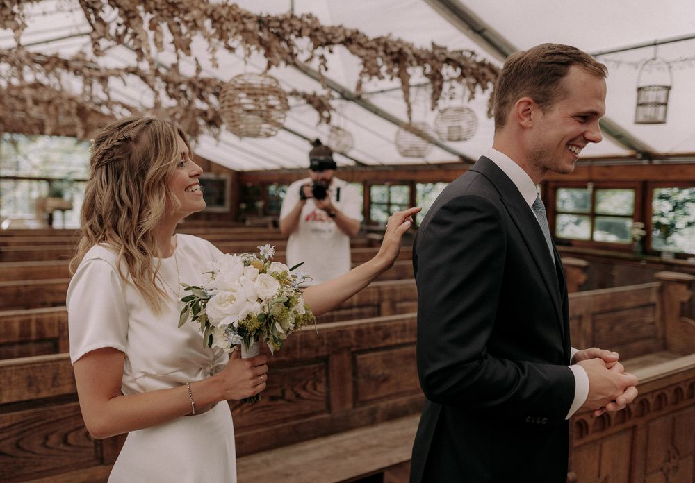 Wedding couple during first look moment in rustic wooden chapel.