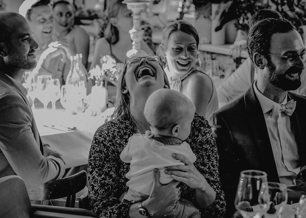 Joyful moment shared between guests at a wedding reception, including a small baby.