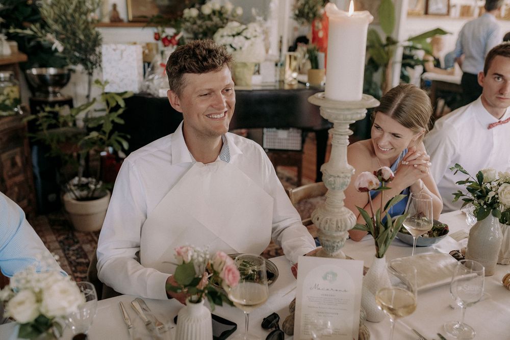 Wedding guests share a lighthearted moment at an elegantly decorated table.