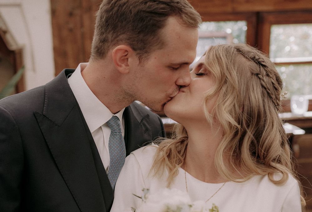 Romantic kiss between couple in rustic indoor setting.