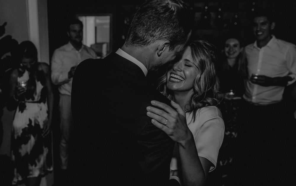 A romantic black and white moment captured during a wedding reception dance.