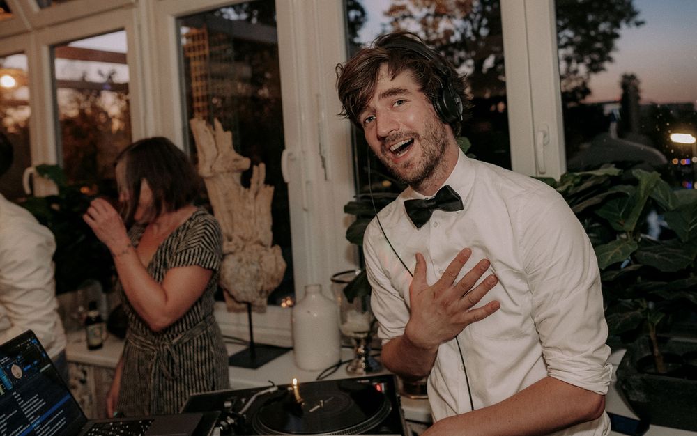 Guest in bowtie expressing joy and excitement during wedding celebration.
