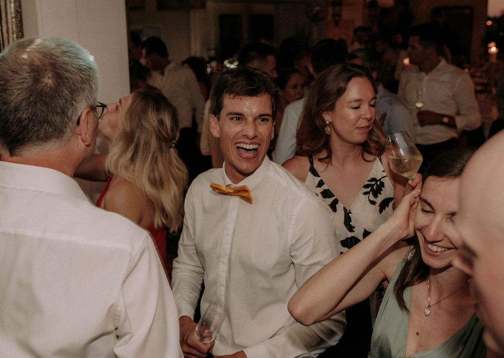 Wedding guests dancing and celebrating with joyful expressions.