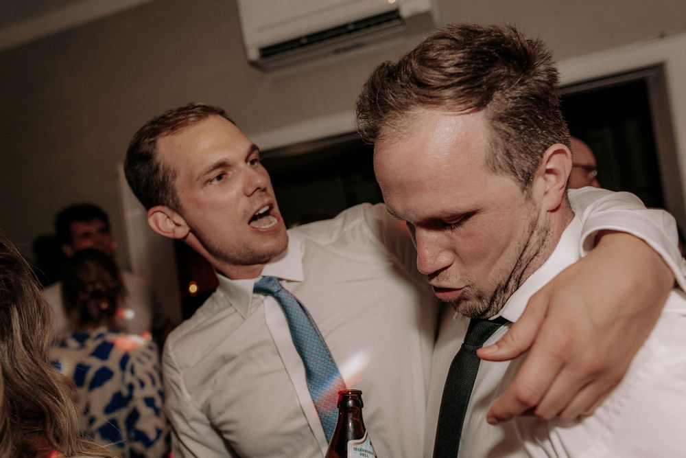 Friends sharing an energetic moment at indoor party.
