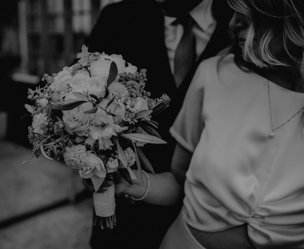 Black and white image of a wedding bouquet with roses and mixed flowers.