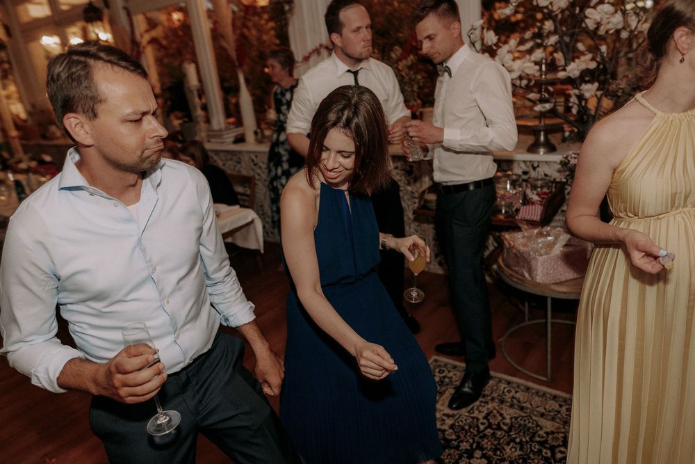 People enjoying themselves at an indoor celebration with elegant decor and ambient lighting.