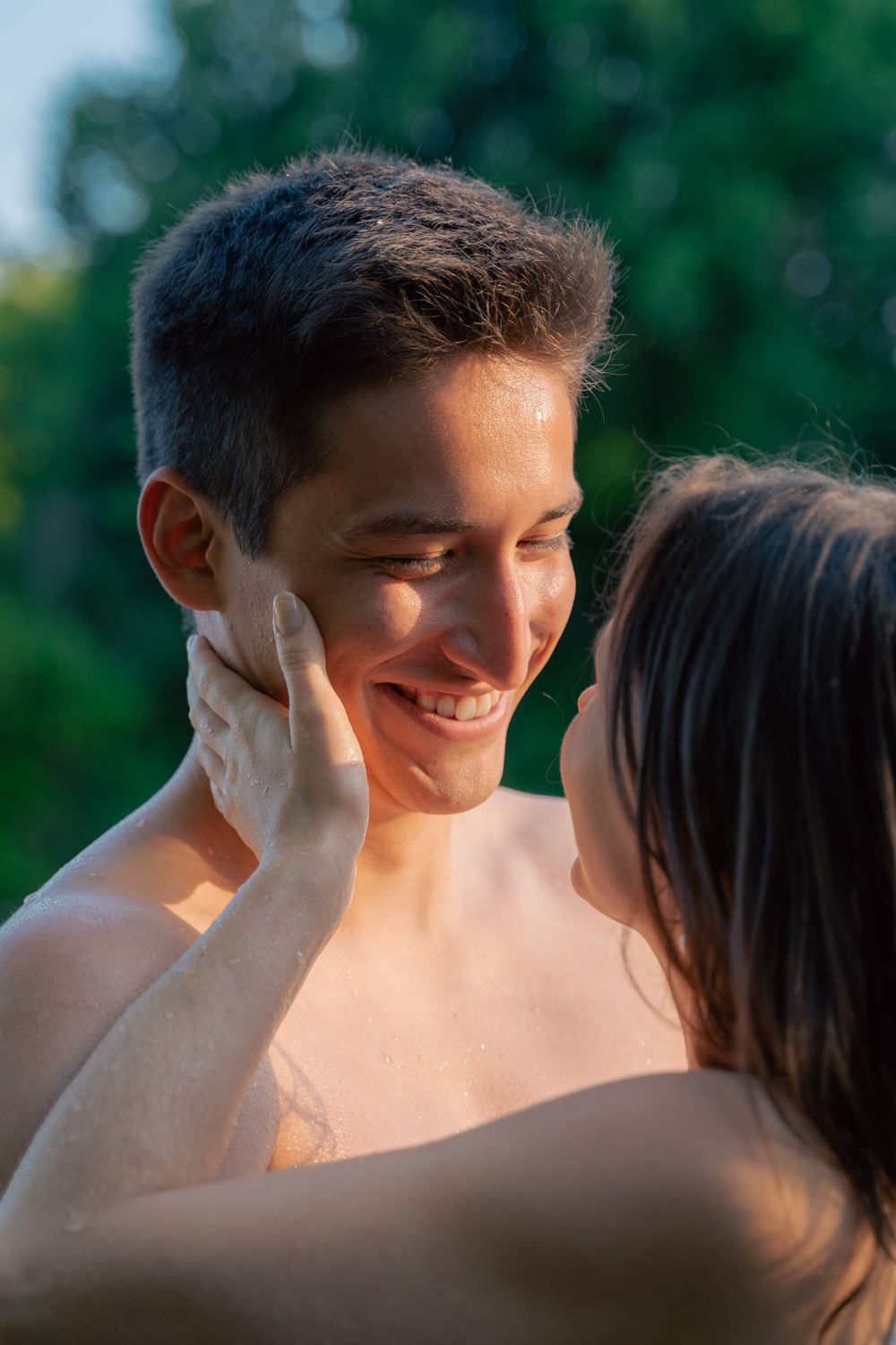 Close-up shot of couple sharing an intimate moment outdoors during golden hour.