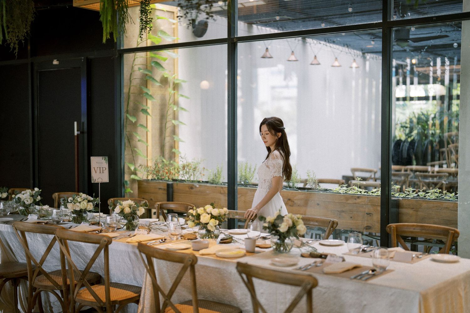 Modern restaurant interior with large windows and elegant table settings for a wedding reception.