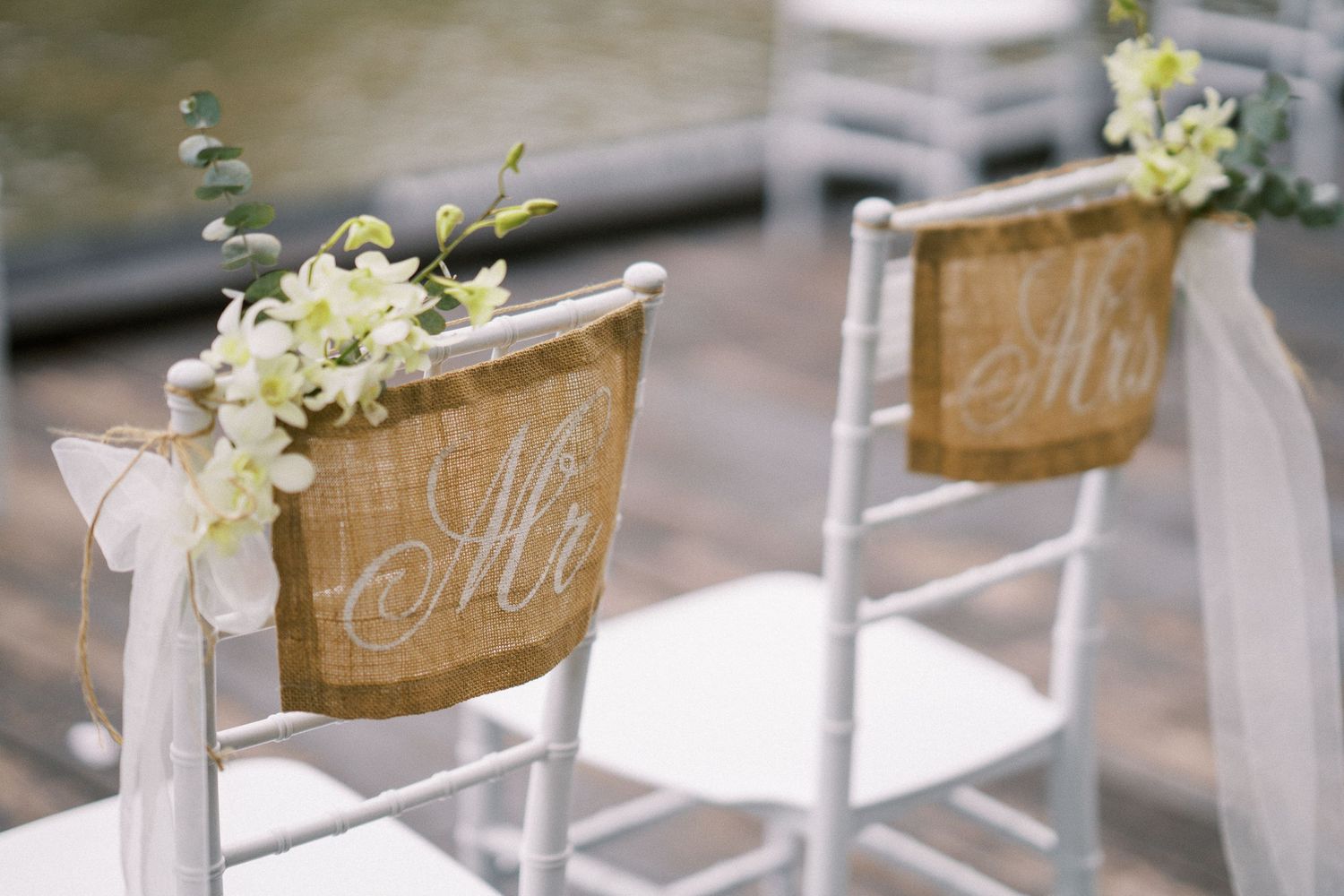 Wedding chair decorations featuring white fabric and floral accents along the aisle.