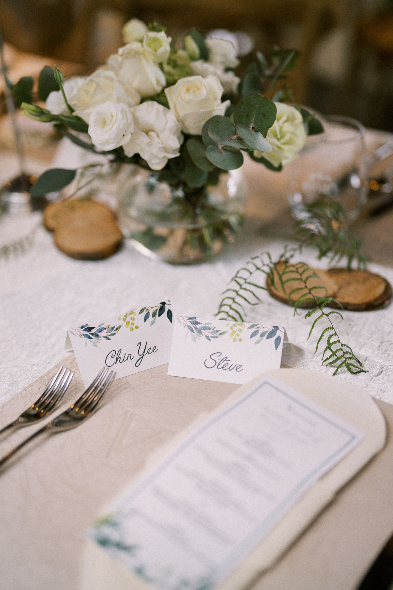 Wedding reception table settings with elegant place cards and floral centerpieces.