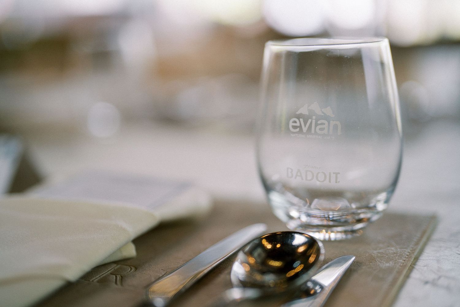 Clear glass stemware arranged on white tablecloths at an elegant wedding reception.