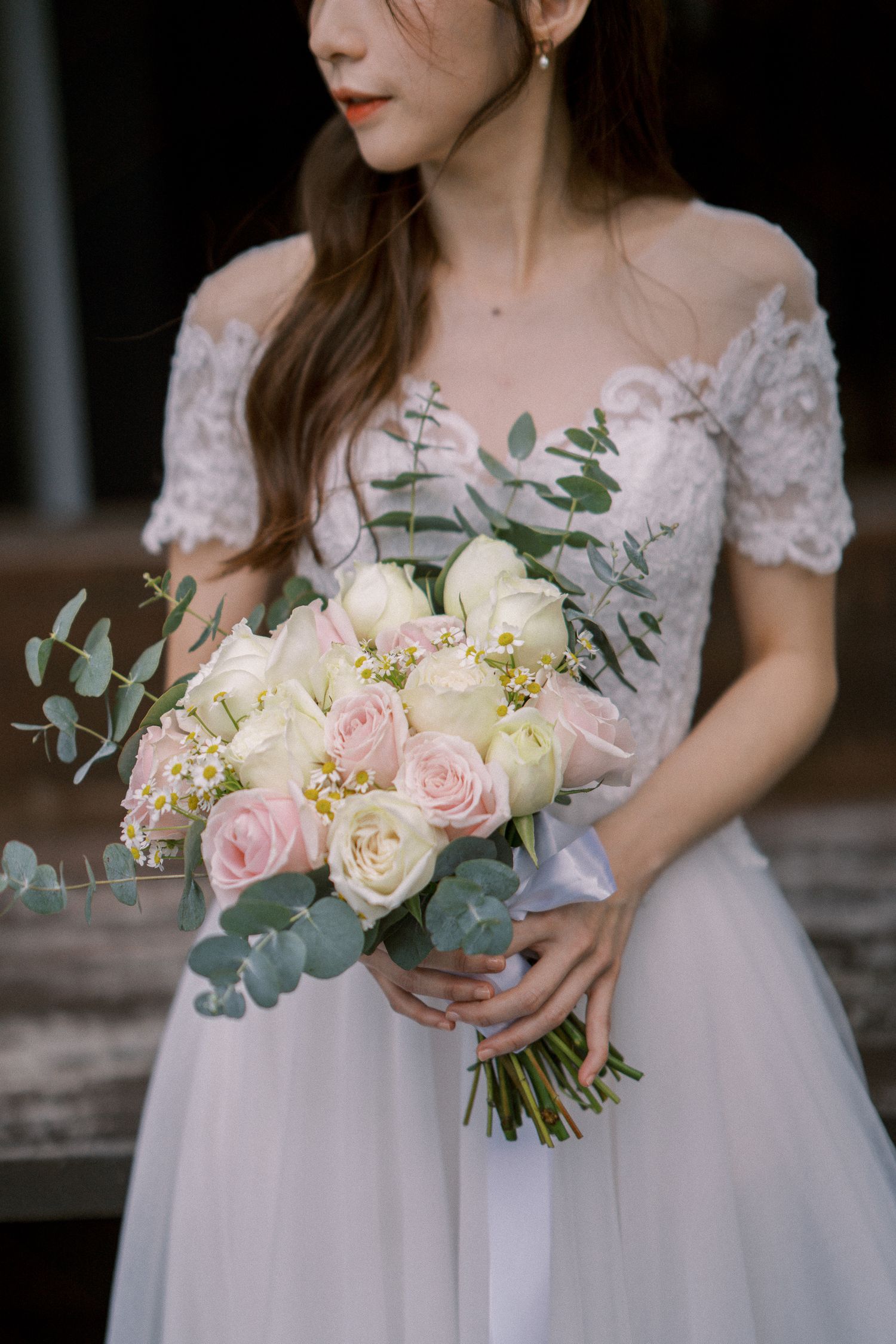 A delicate bridal bouquet featuring pink and white roses with eucalyptus leaves.