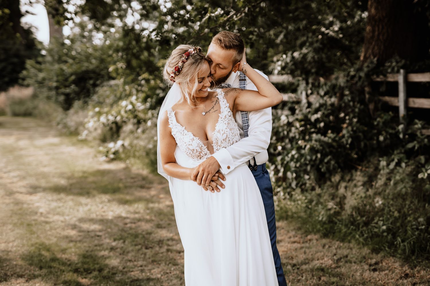 Intimate wedding moment shared between couple in white dress and formal attire outdoors.
