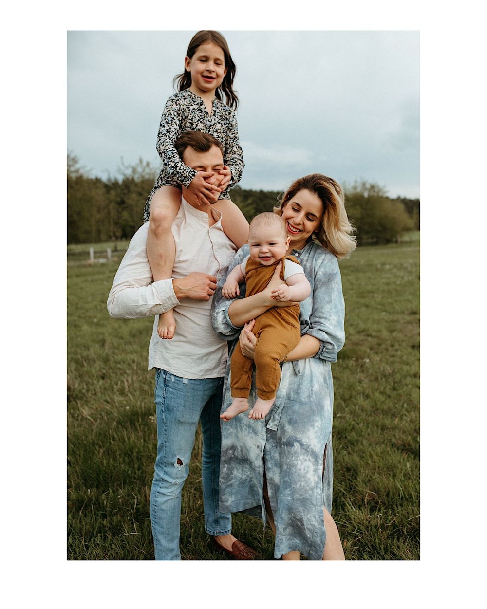 A tender family moment captured in a rustic outdoor setting with natural lighting.