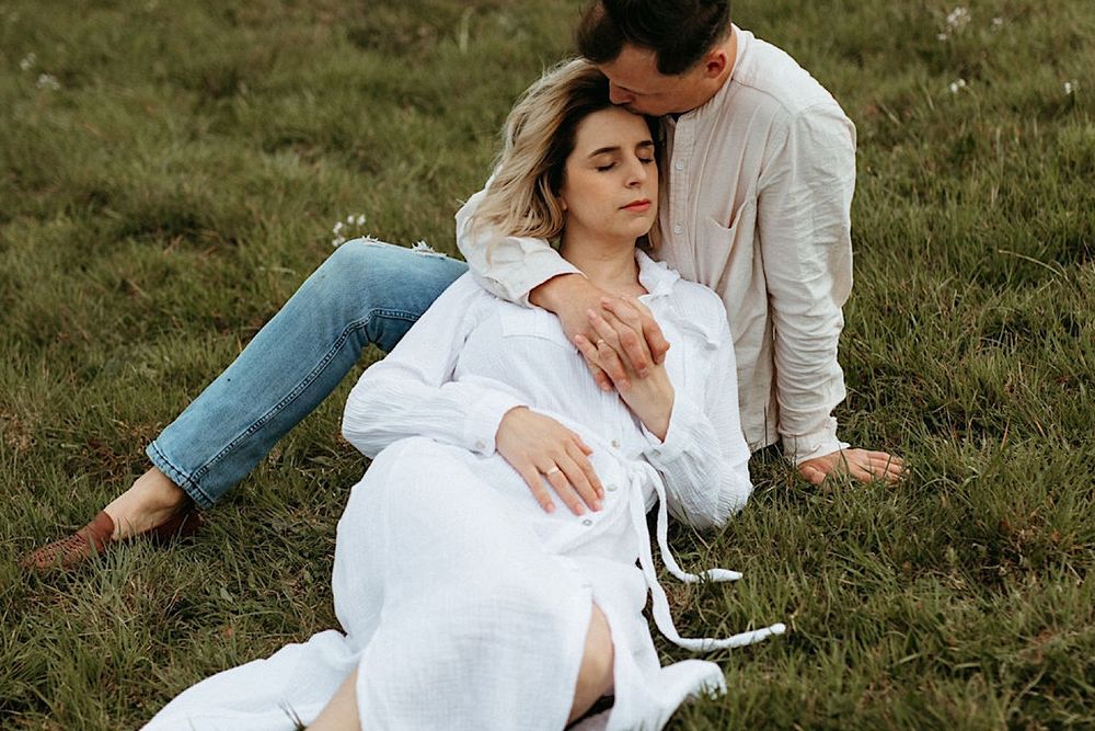 Romantic photo series capturing intimate moments between a couple lying in grass.