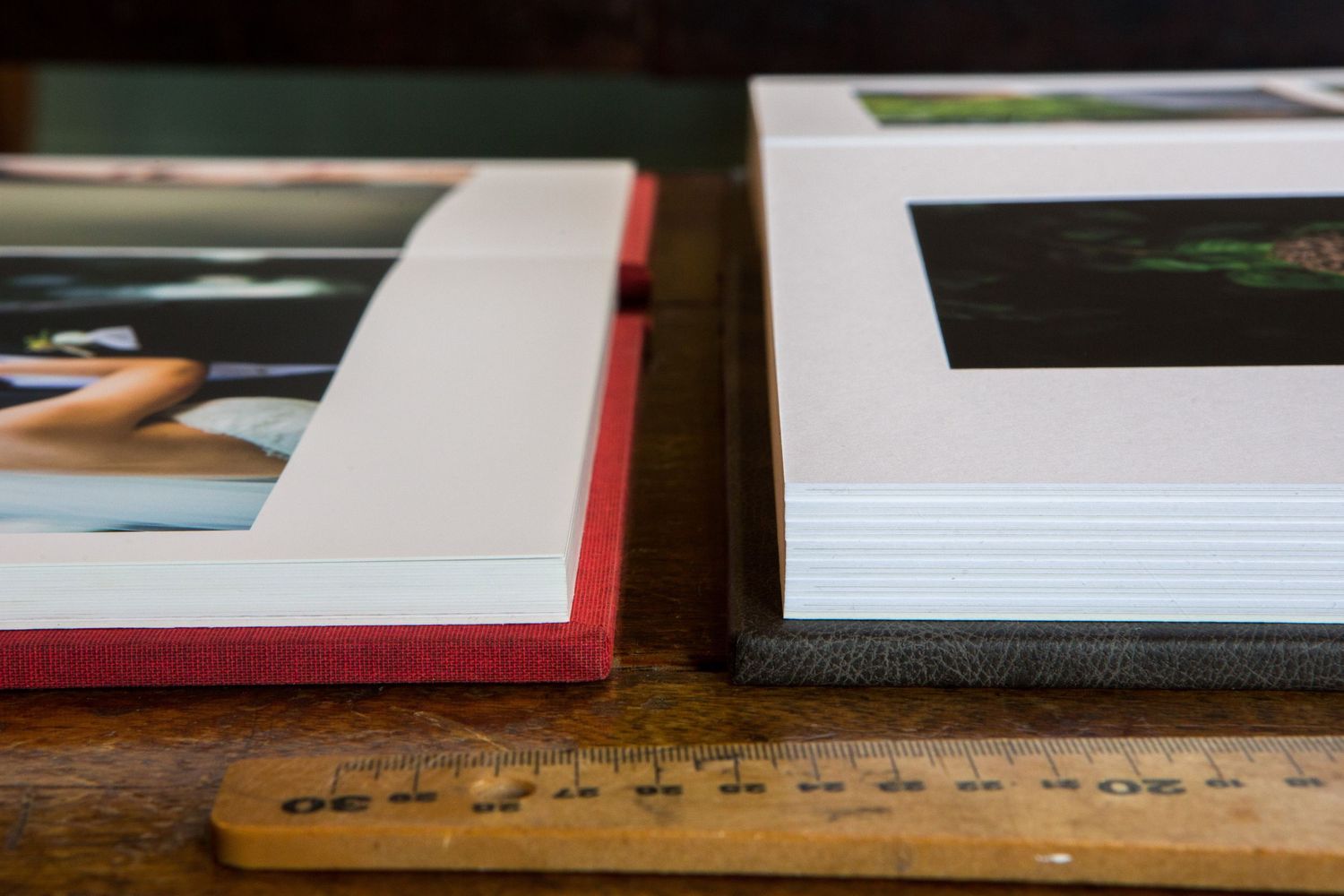 Photo albums with matted frames and a vintage wooden ruler on a table.