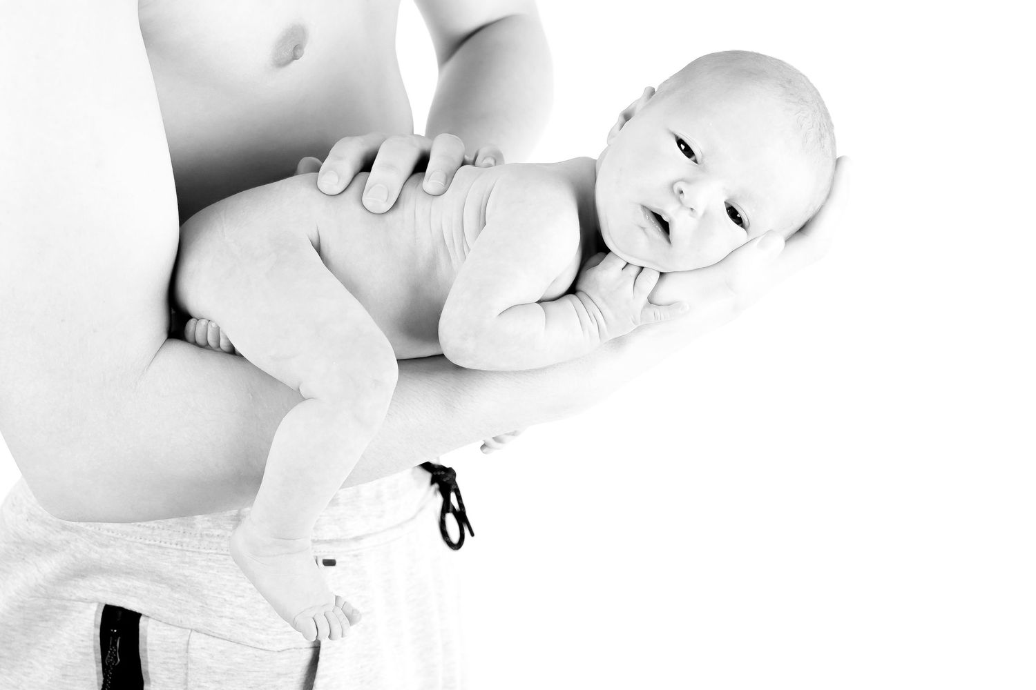 Black and white artistic portrait of newborn baby on white background.