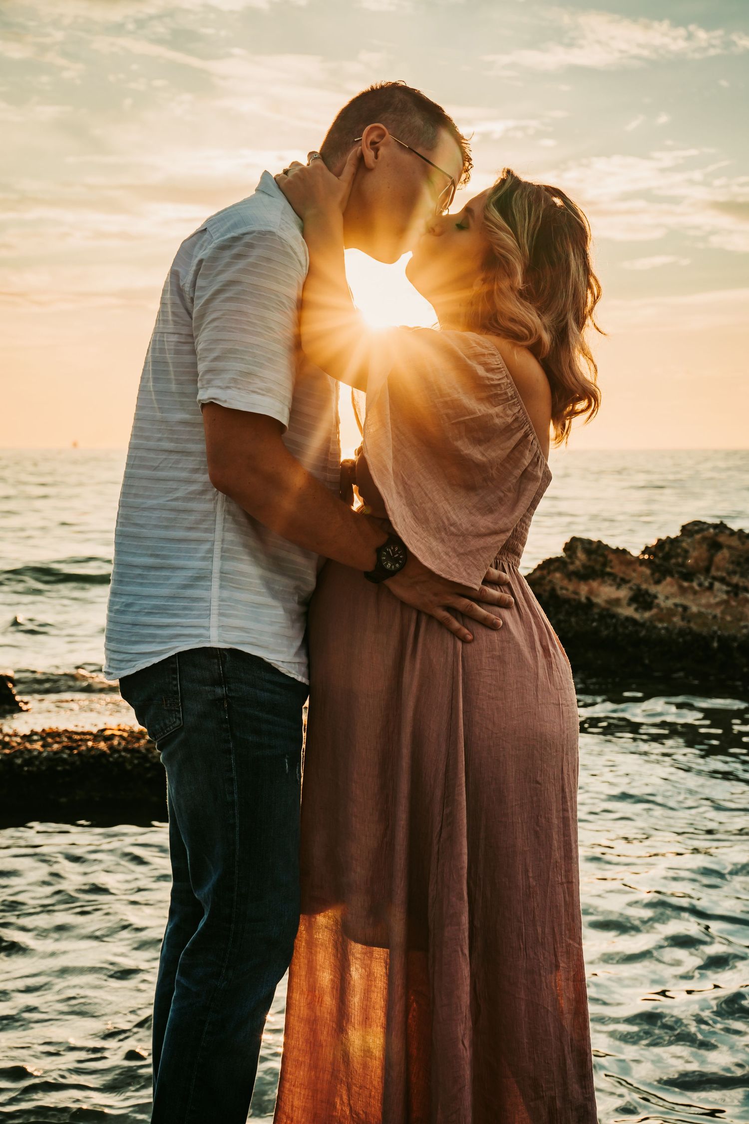 Outdoor Maternity Session at Ft. Desoto in St. Pete, FL; couple bathed in sunlight on the beach at sunset kissing