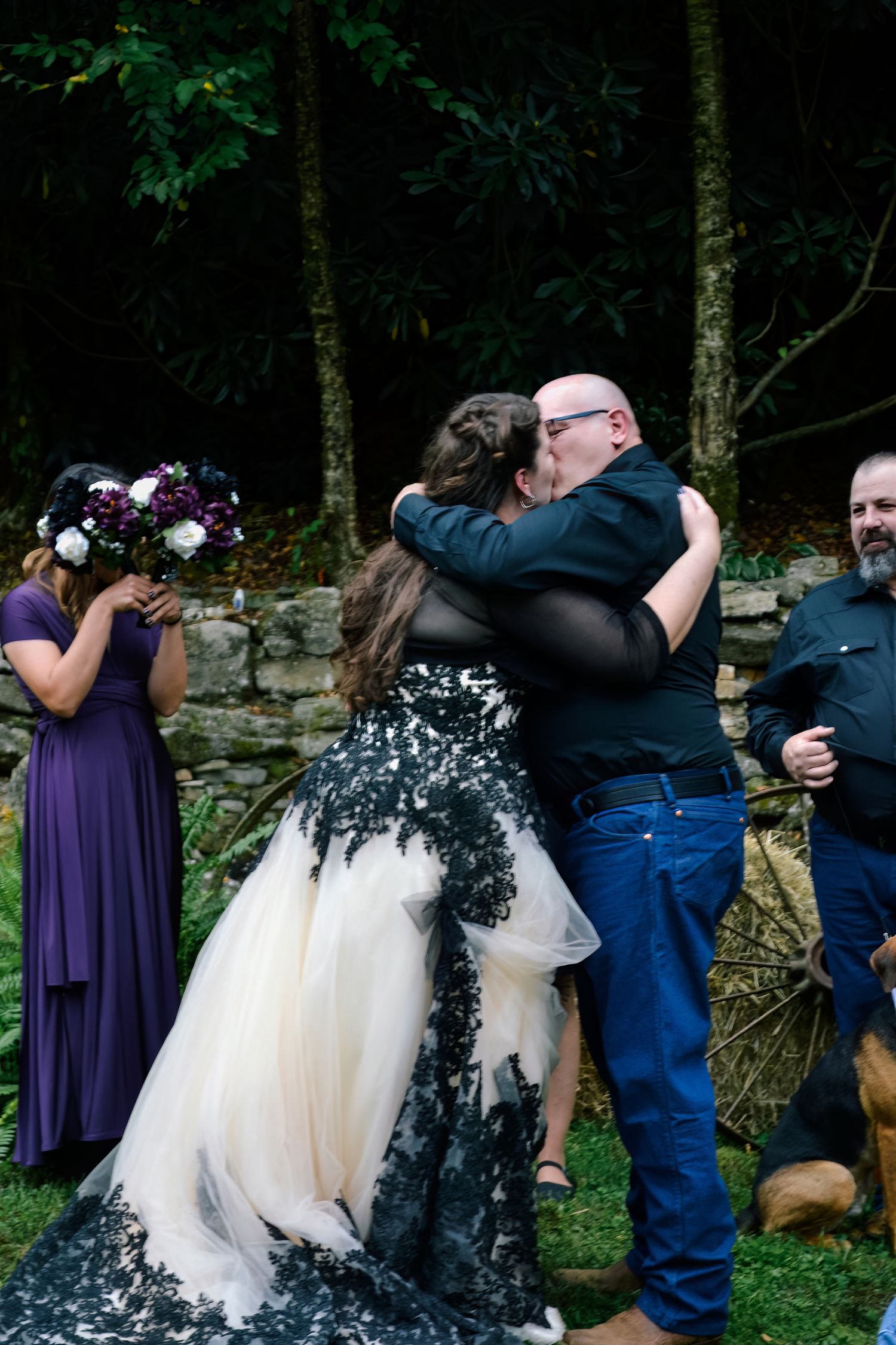 A dramatic black and white wedding dress with lace overlay worn during an outdoor ceremony.