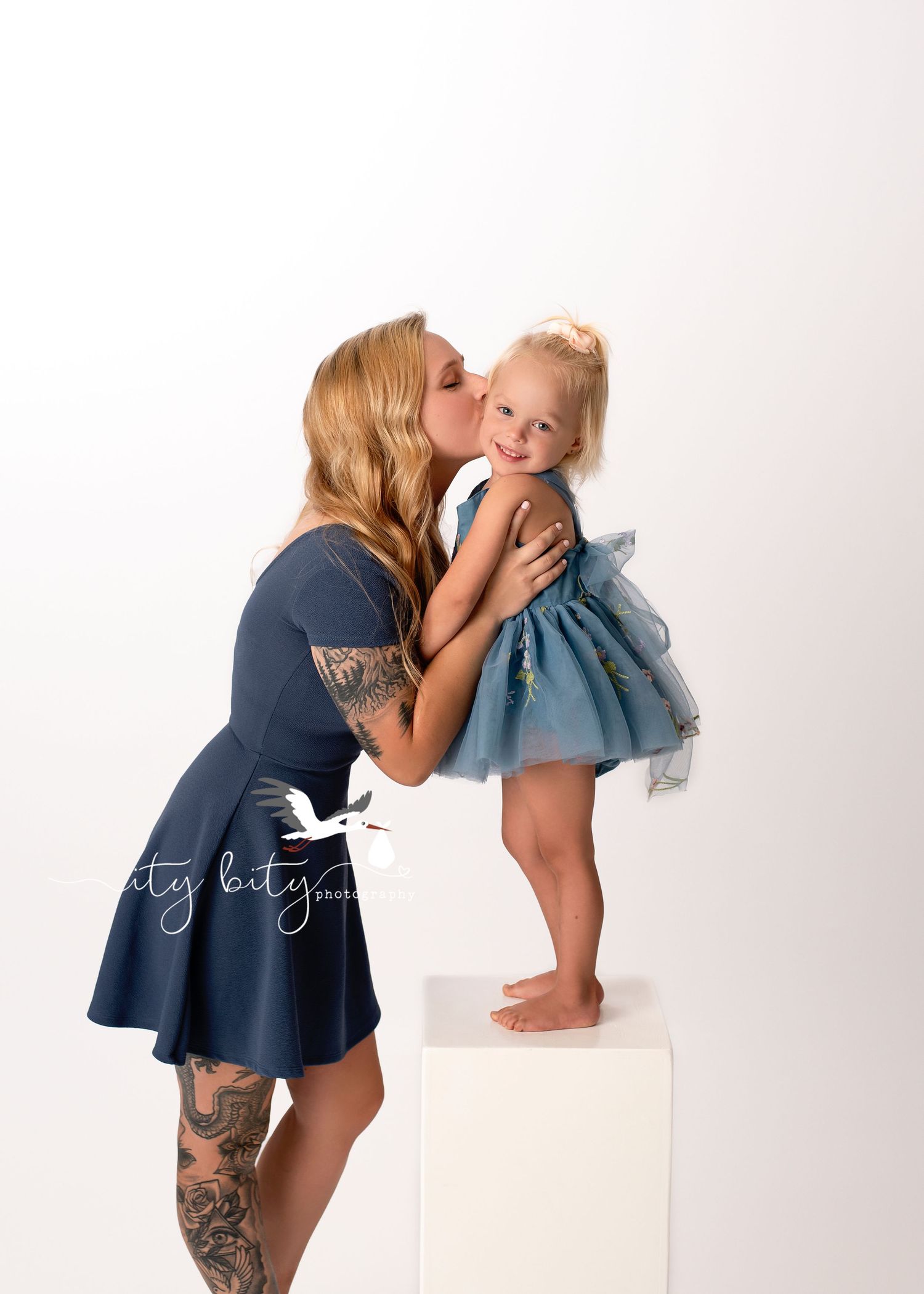 Mommy & daughter Layla share the sweetest cheek kiss during brothers One year cake smash photography session Lakewood