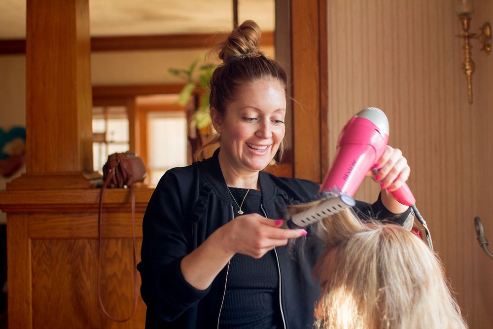 Wedding hair and makeup preparation session in warm indoor lighting.