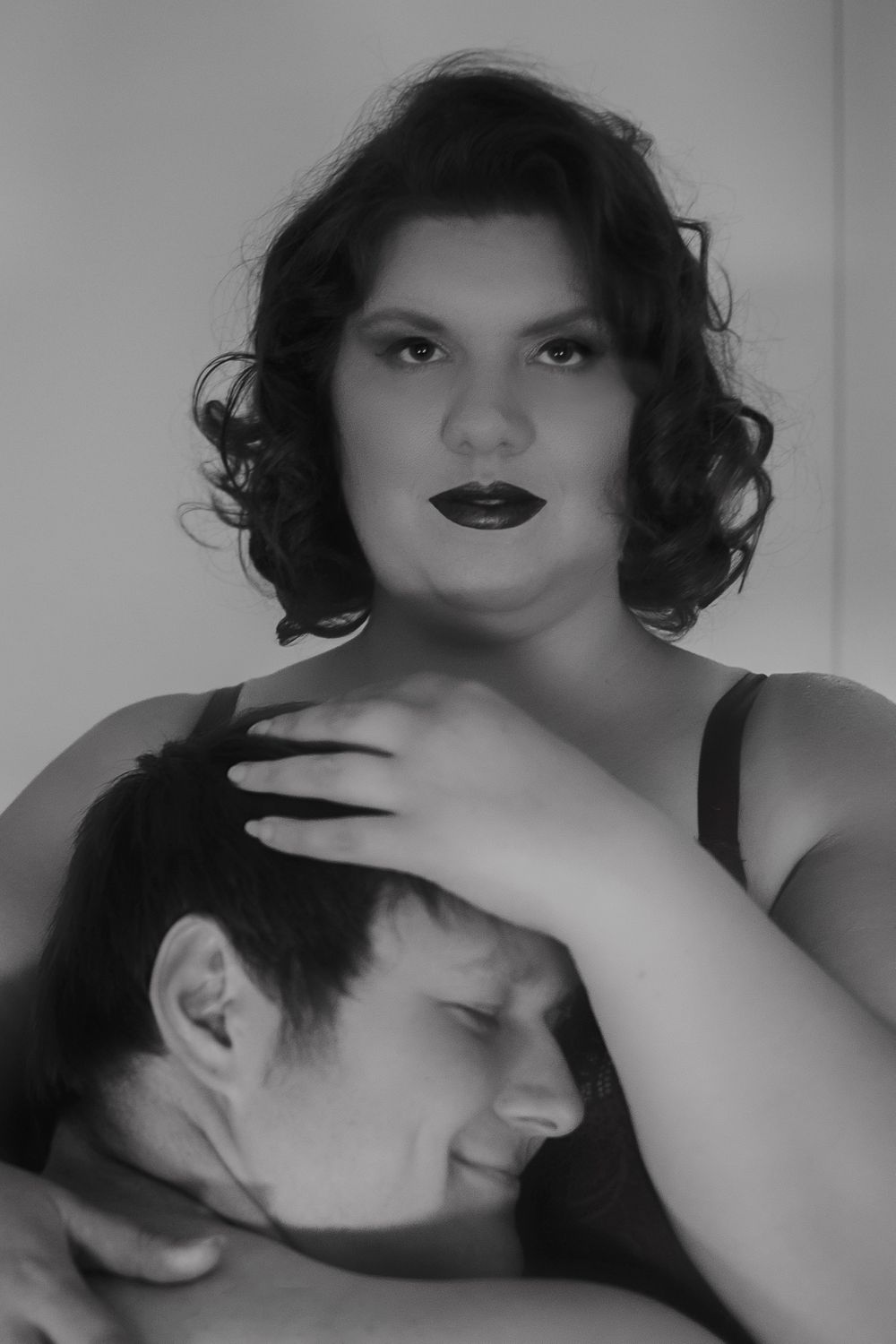 A dramatic black and white portrait capturing an intimate moment between two people.