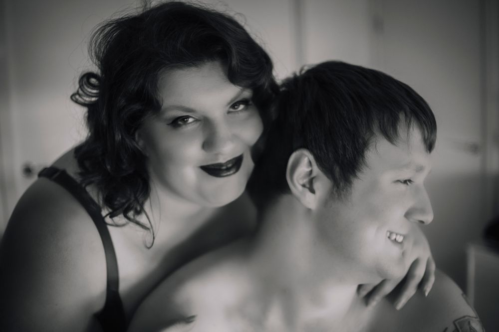 A joyful black and white portrait capturing a playful intimate moment.