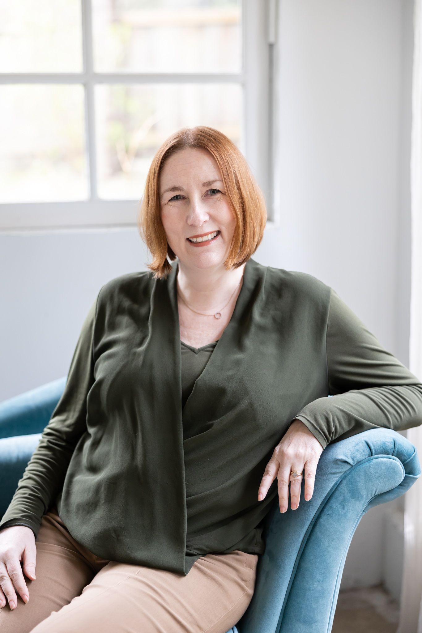 woman business owner of compression gloves Grace & Able headshot sitting on couch in Woodinville, WA