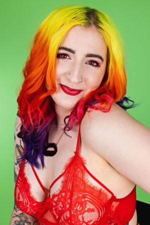 Eliza a rainbow haired femme person in a wheelchair wearing red bra shot in studio in Hove