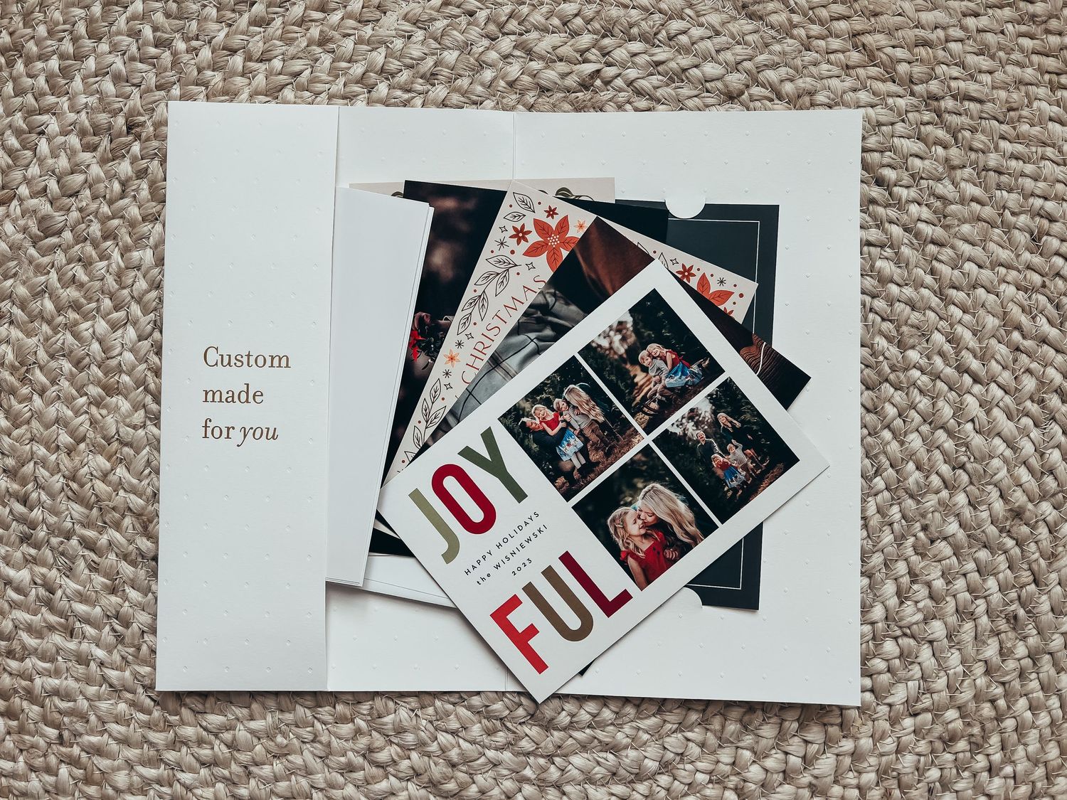 a large white elvelope holding a fanned stack of family Christmas cards ordered as a sample from Basic Invite