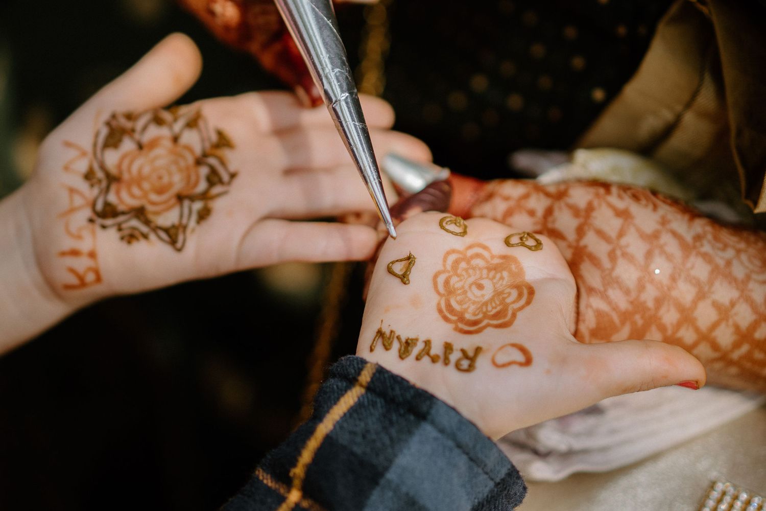 Close-up of intricate henna designs being applied during traditional Indian pre-wedding ritual.