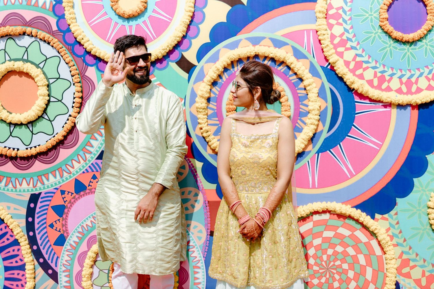 Colorful mandala backdrop with vibrant pink, blue and orange patterns at an Indian celebration.