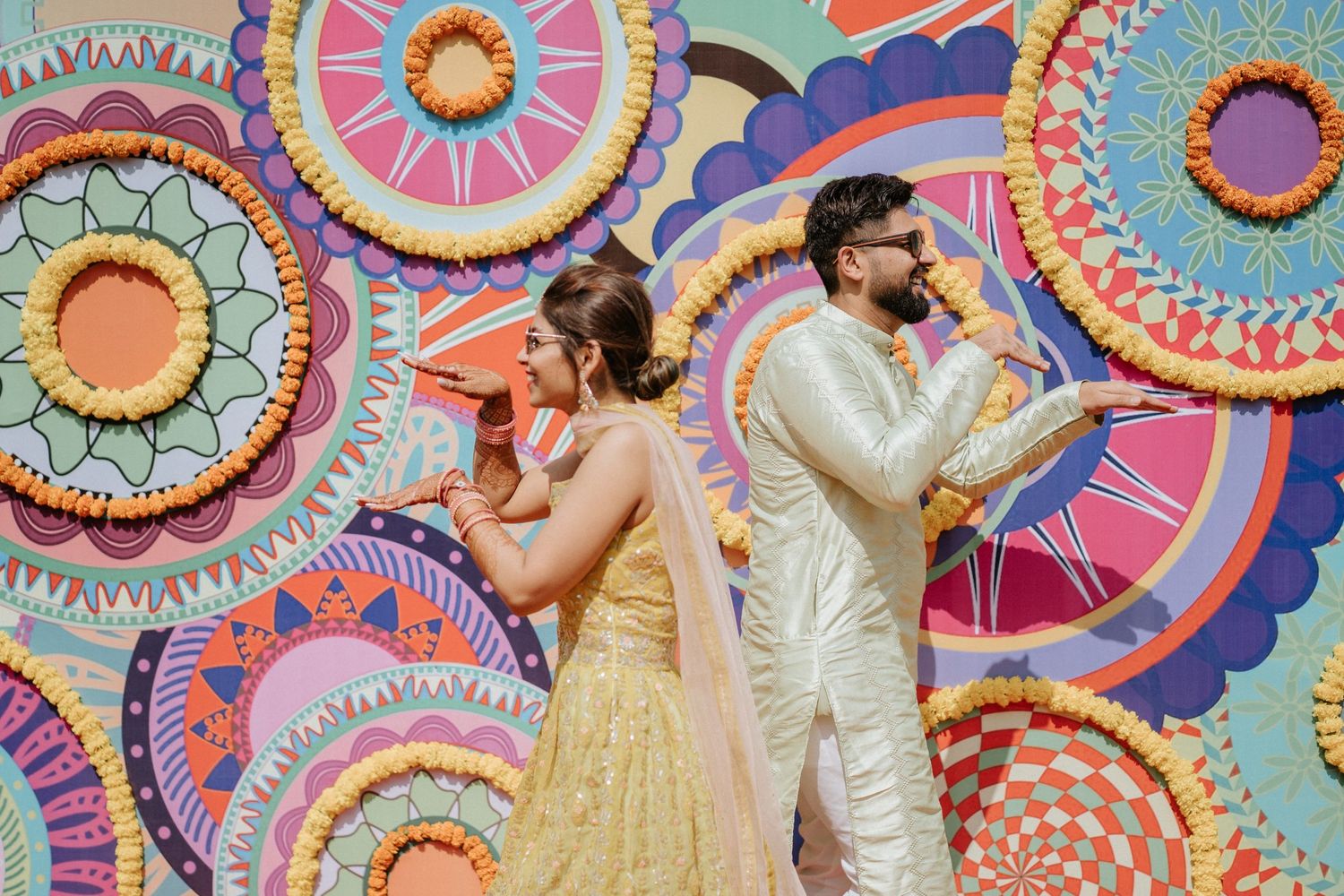 Festive gathering with bright geometric backdrop featuring circular patterns in pink and blue tones.