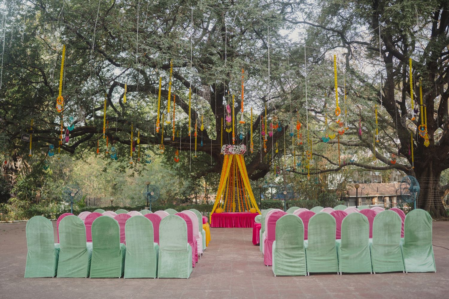 Row of mint green and pink chairs set up for outdoor ceremony.