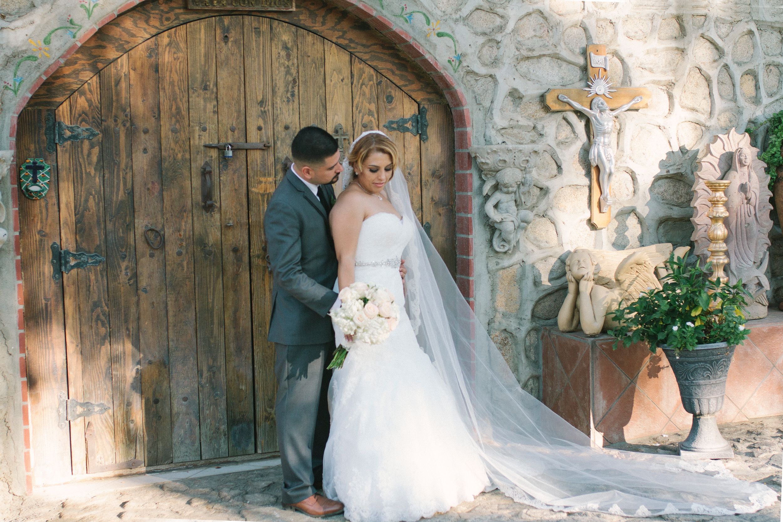 Rustic stone archway with wooden doors at wedding venue.