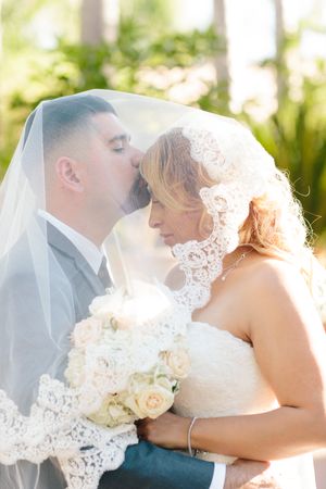 Sunlit wedding portraits capture romantic moments between newlyweds with white roses.