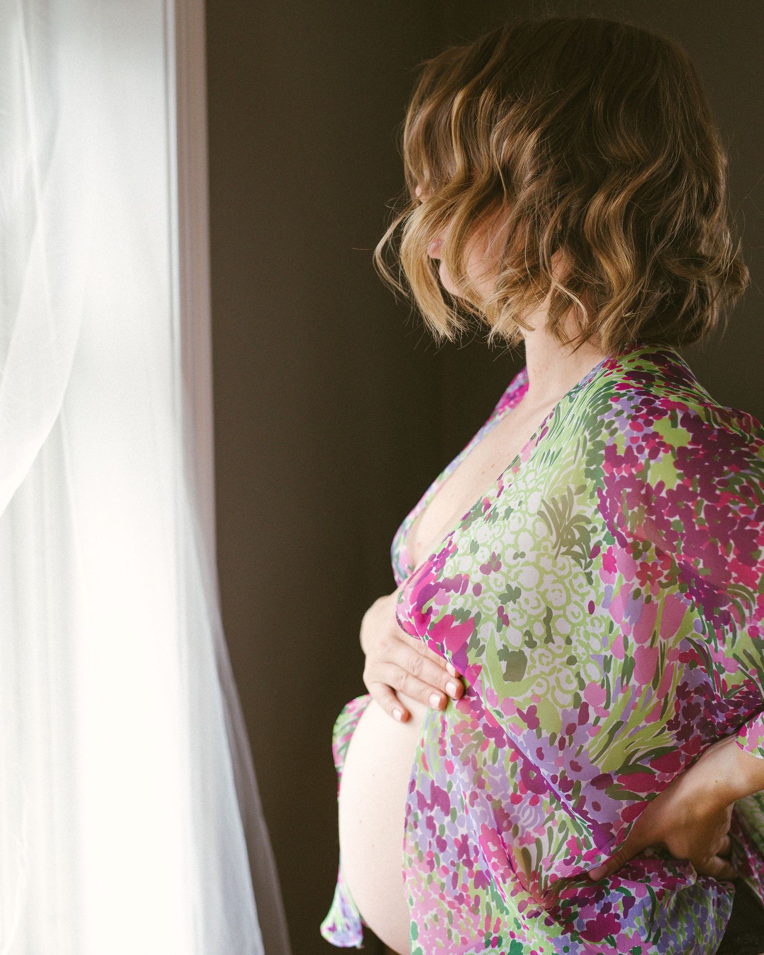Profilen til en gravid kvinne med naken mage.