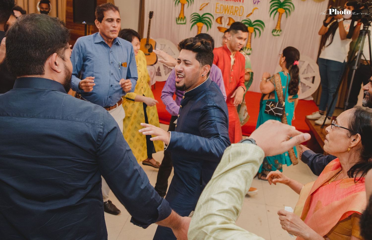 Celebration event with colorful tropical decorations and multiple people interacting.