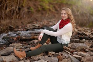 woman with knee up sitting in front of stream of water