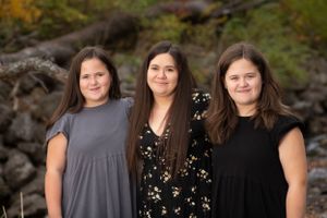 woman standing between 2 daughters