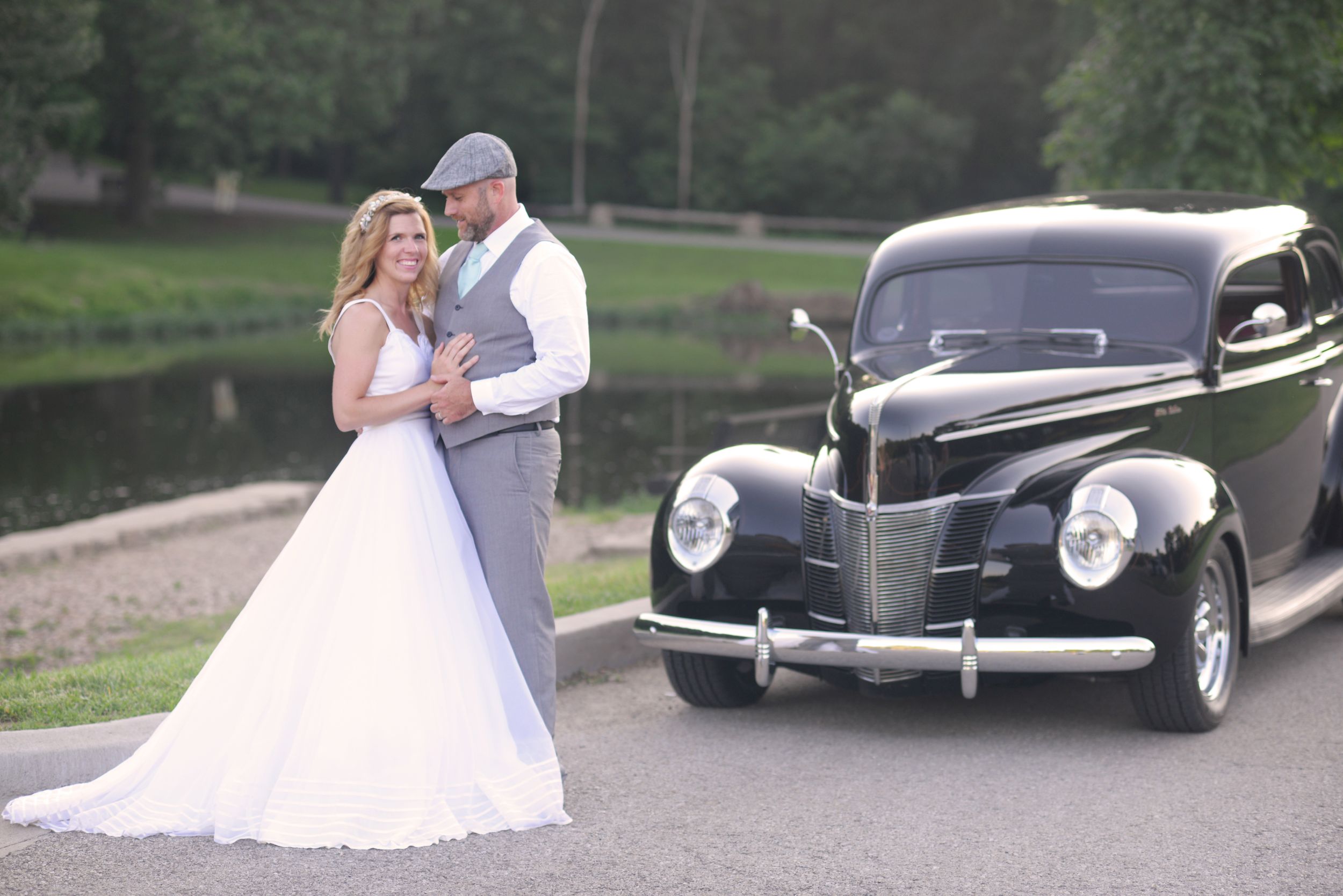 husband looking at bride in front of vintage car