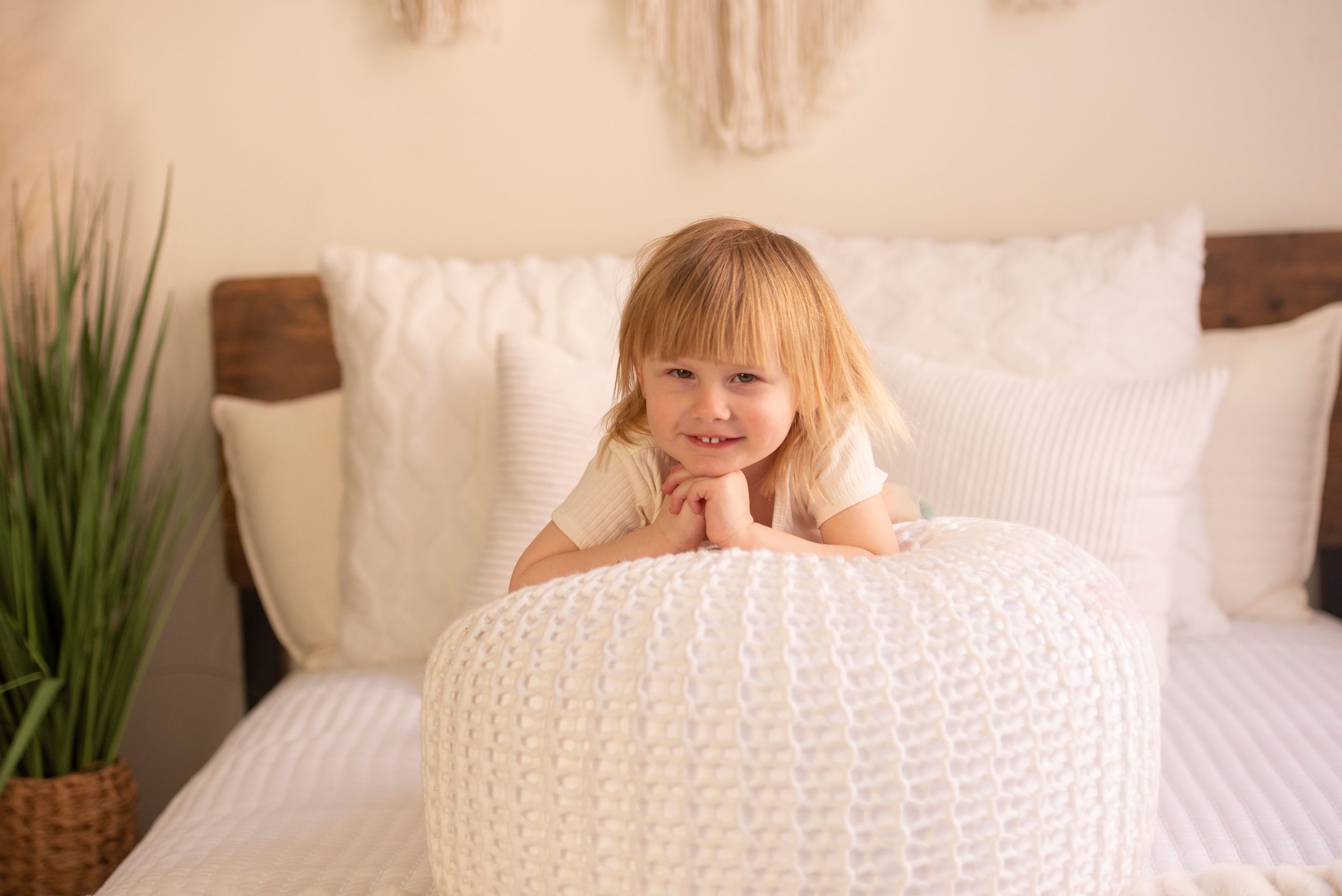 child on beanbag with hands under chin and smiling