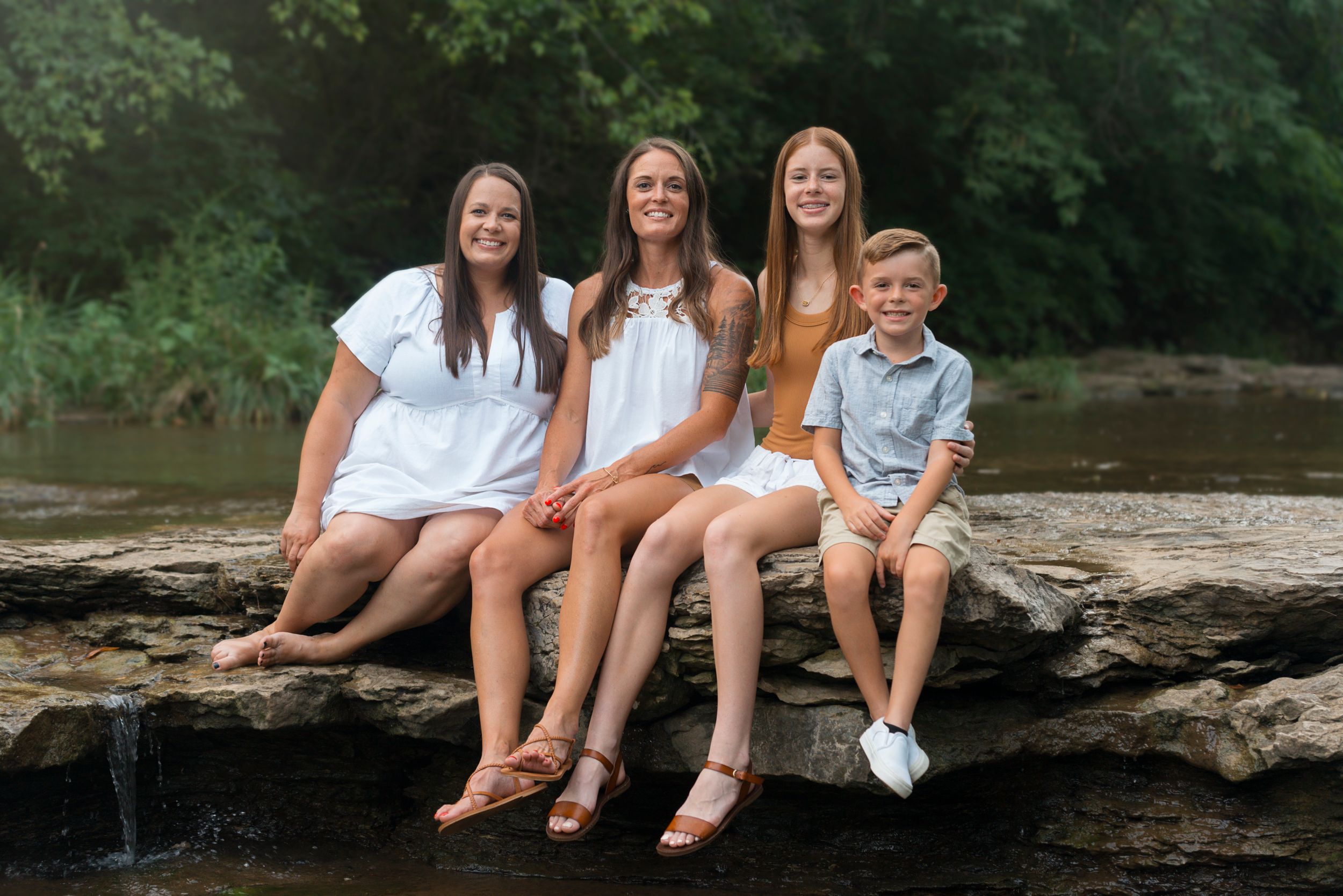 Family of 4 sitting on rocks together