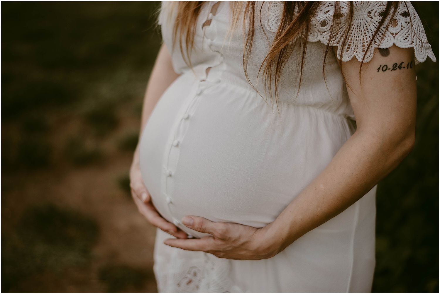 Detail shot of a buttoned maternity dress with delicate lace trim in natural lighting.