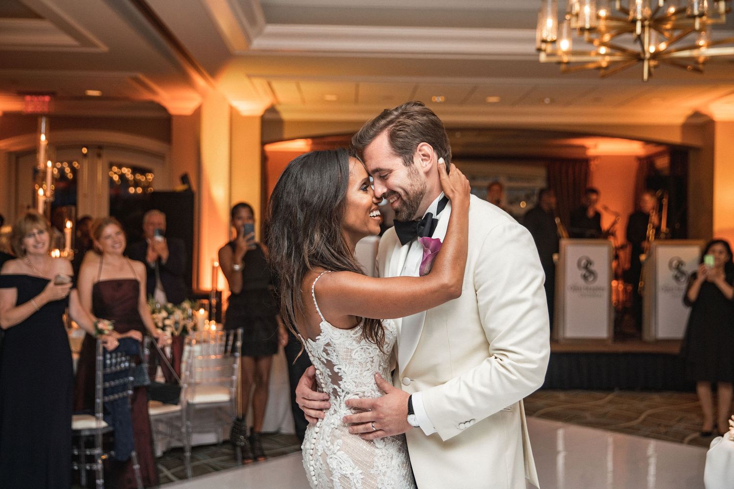 A couple shares their first dance as newlyweds on an elegant ballroom floor.