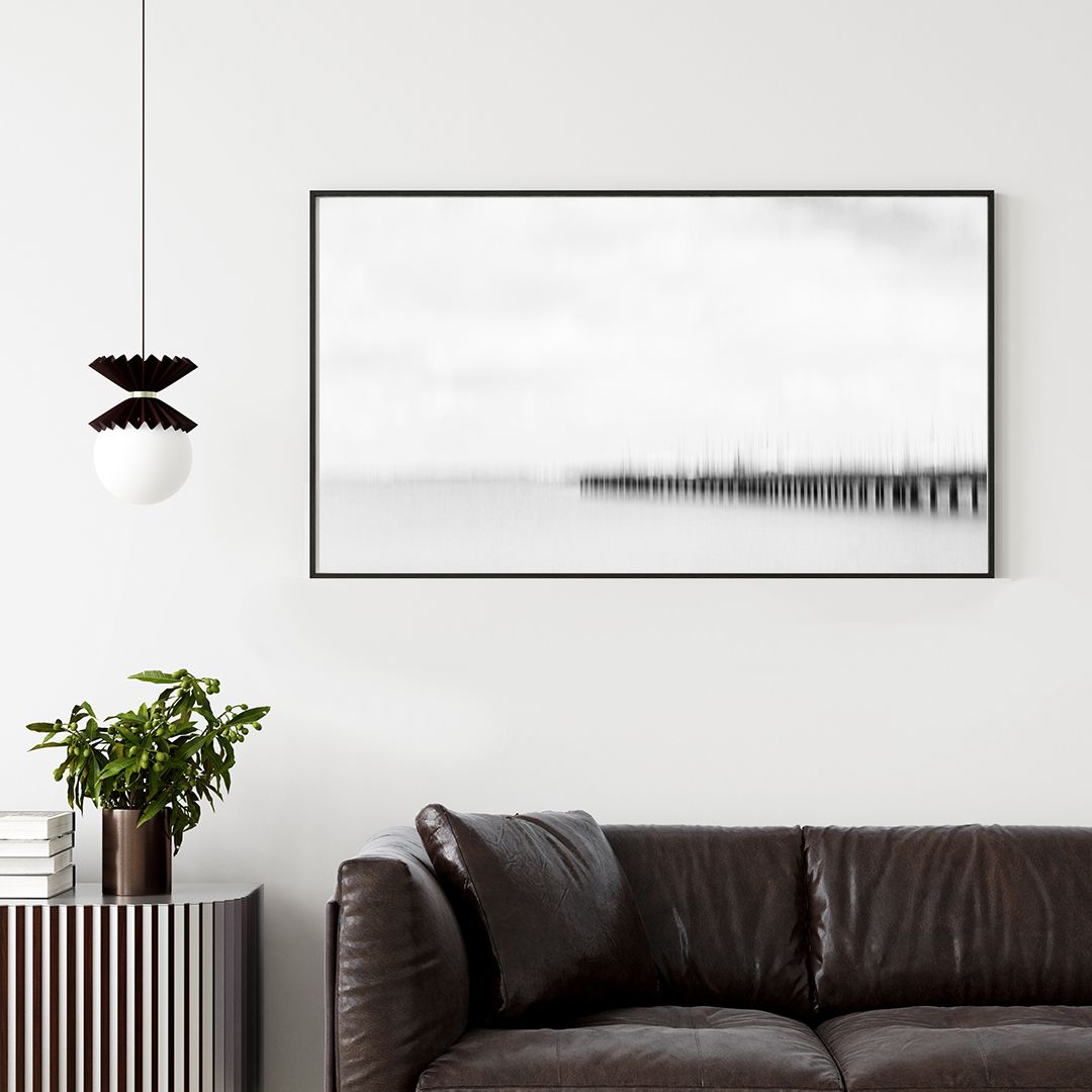 Contemporary living room with leather sofa and minimalist black and white wall art.