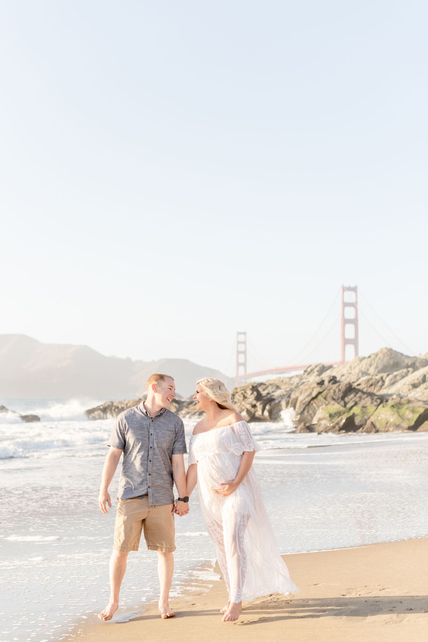 Light and airy beach maternity photo with Golden Gate Bridge in background.